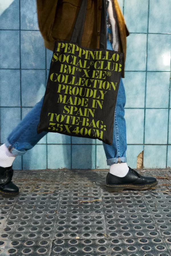 Tote bag mockup worn by a guy with jeans who is walking in the parking of a burger restaurant. Clothing mockup. Fast food PSD file. Takeaway mockup. Fast food mockup. Premium quality tote bag mockup. Tote bag PSD high-quality editable file. Tote bag high-quality mockup. Bag PSD file.