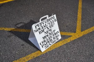 High quality mockup of a white paper bag placed on the road out for delivery. Packaging mockup for fast food restaurant brand. Food mockup. Premium paper bag mockup for fast food brand.