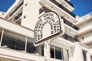 Premium mockup of a restaurant sign outdoors for your brand. High quality mockup of a restaurant sign set outdoors beside a building shot from below. Outdoors mockup. Editable PSD file for Adobe Photoshop.