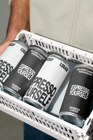 Person holding a tray with Espresso Yourself coffee cans