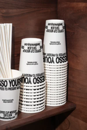 Stack of Espresso Yourself coffee cups on a wooden shelf