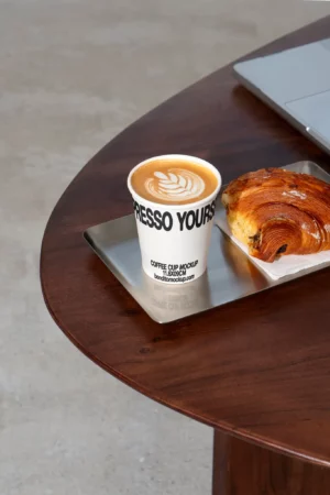 Espresso Yourself cappuccino cup with pastry on wooden table