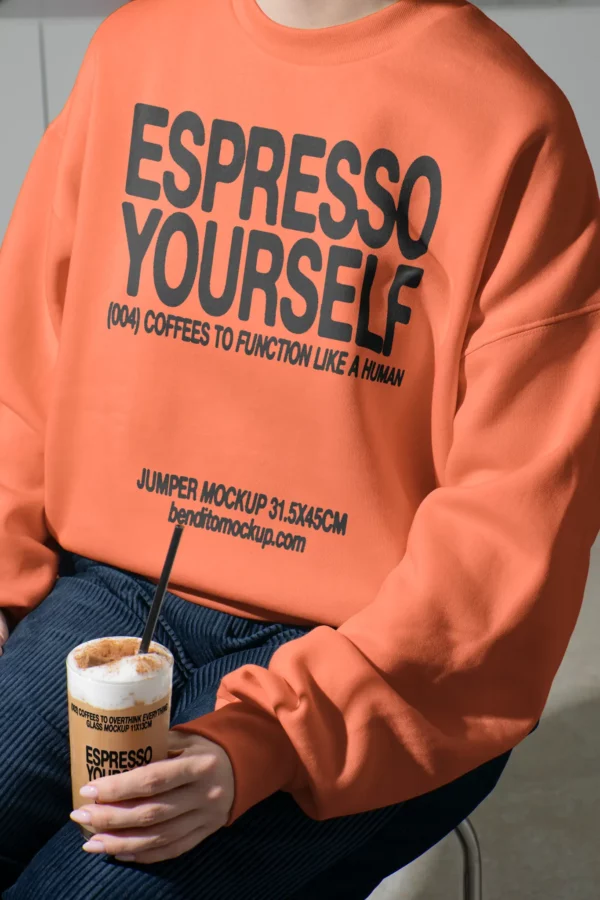 Color Version: Person wearing an Espresso Yourself jumper while holding a cup of iced coffee