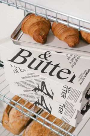 Box mockup from the Bread & Butter collection on a metal rack with croissants.