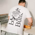 Baker t-shirt mockup from the Bread & Butter collection where a person is using a rolling pin on dough.