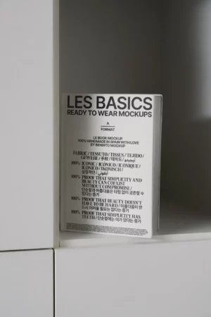 Closed white book mockup displayed on a minimalist shelf with subtle lighting.