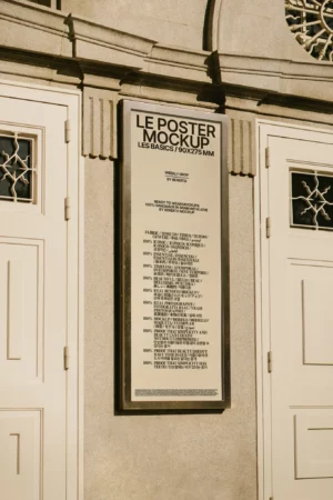 Vertical framed poster mockup mounted on a stone wall with minimalistic surroundings.