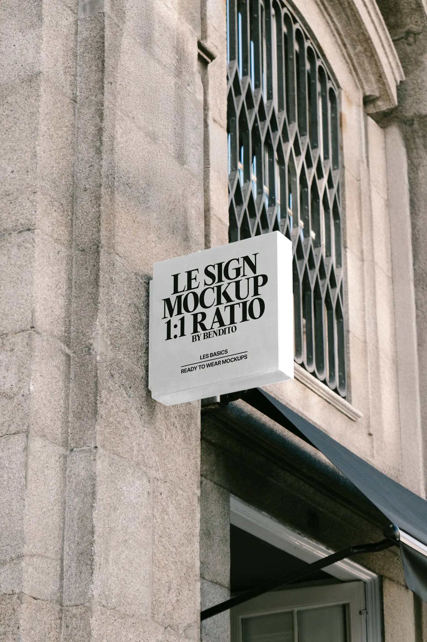 Color Version: A black square signage mockup mounted on a stone wall, with holiday garlands in the background.