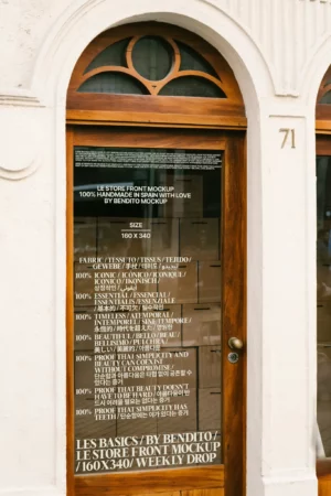 A wooden-framed storefront mockup with glass catching warm interior light and exterior reflections.
