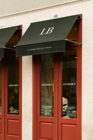 A black awning mockup shading a café entrance with soft shadows and strong structural framing.