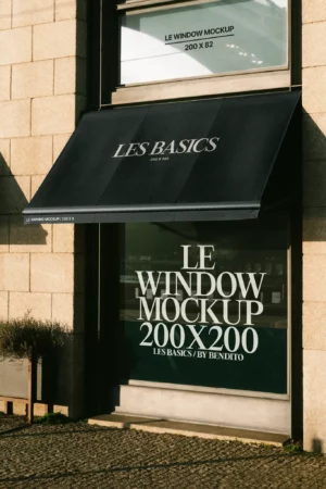 A black awning mockup extending over a large glass storefront with direct sunlight emphasizing its texture.