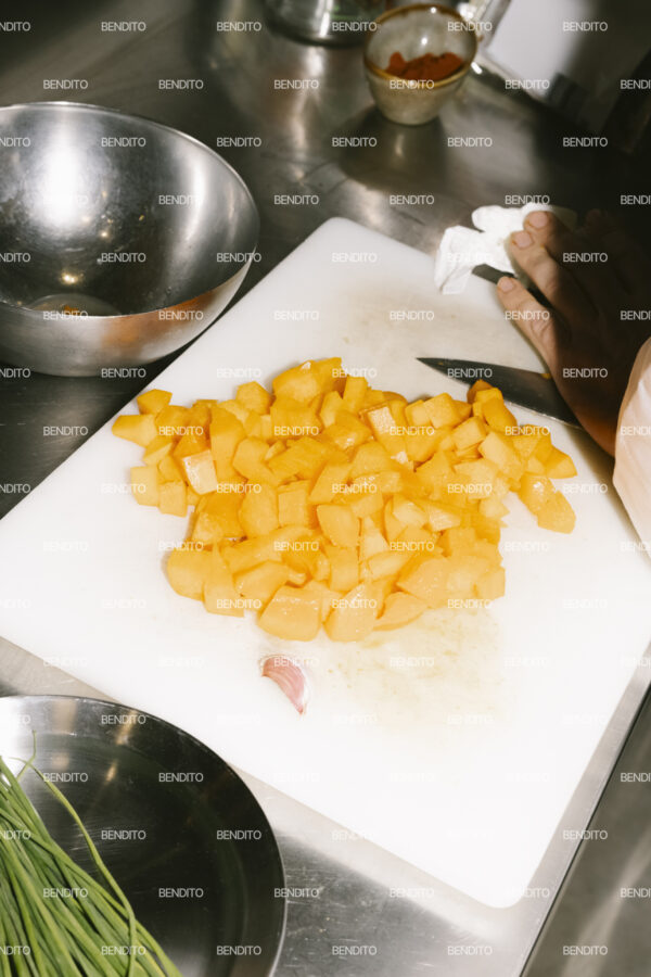 Detailed view of diced vegetables on a cutting board in a kitchen.
