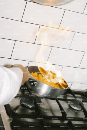 Flames rising from a pan on a gas stove.