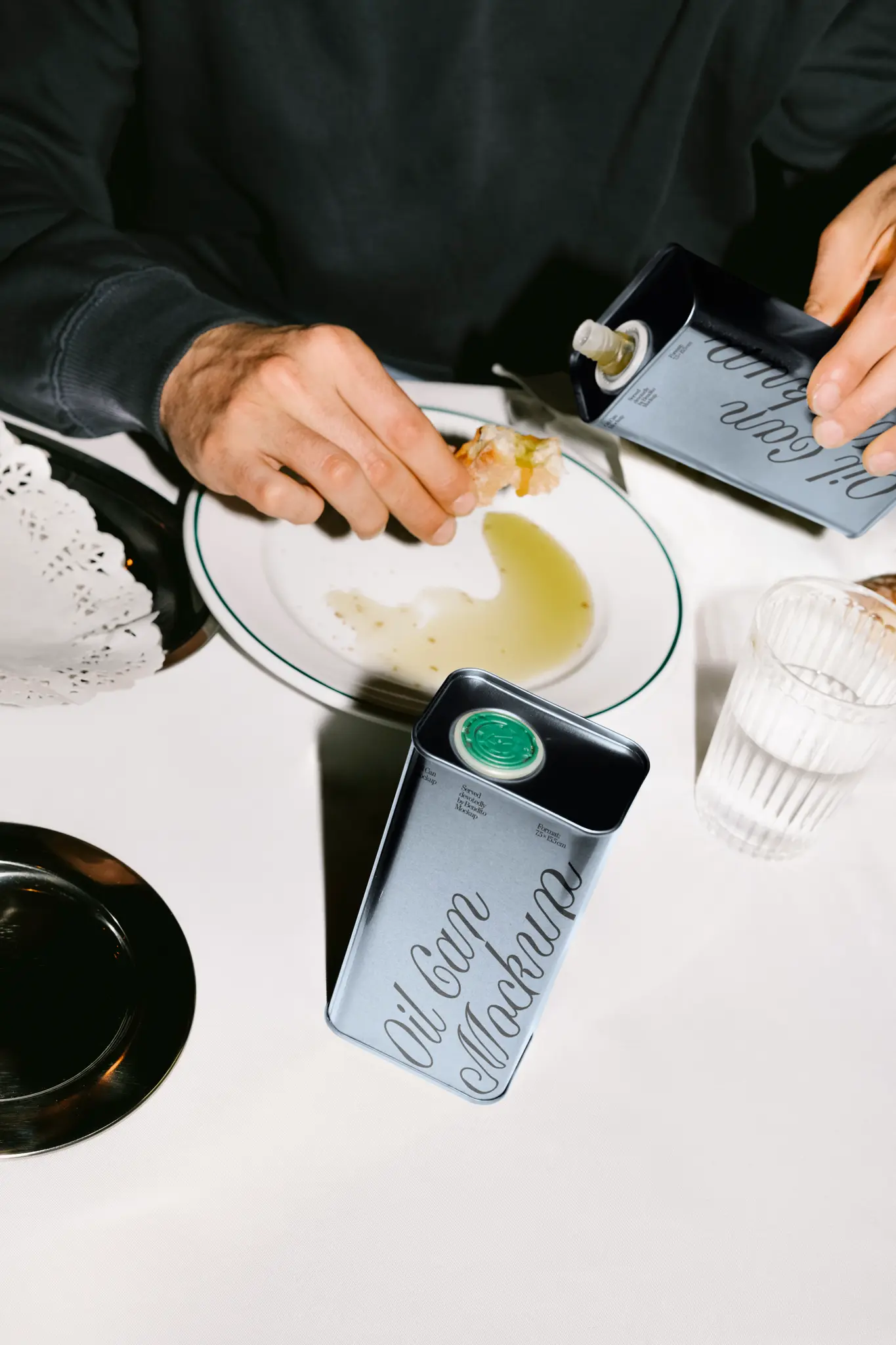 Color Version: Mockup of a metal oil can on a table. Perfect for showcasing olive oil or food-related branding.