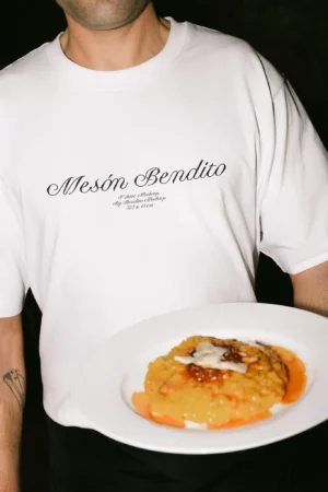 Mockup of chef holding a plated dish while wearing a white t-shirt and apron. Ideal for food service branding.