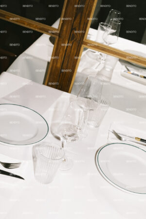 Minimalist tableware arrangement with empty plates and wine glasses.