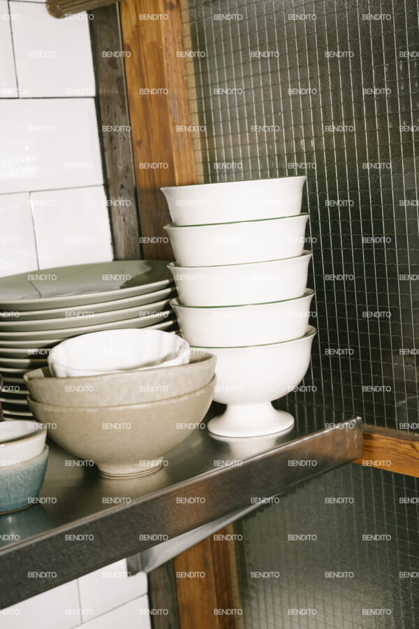 Detailed view of a stack of ceramic bowls in a rustic kitchen.