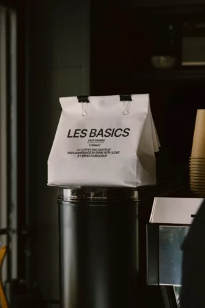 Canvas tote standing on a wooden table surrounded by coffee beans.