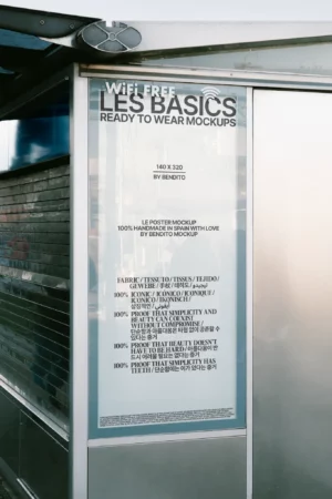 Urban poster mockup displayed behind glass at a bus stop, with minimal text layout—ideal for outdoor campaigns, announcements, or product drops.