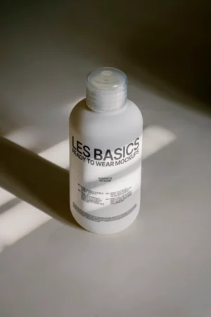 Frosted soap bottle mockup with clear pump cap and minimal design, lit by soft sunlight—ideal for branding personal care or cosmetic packaging.