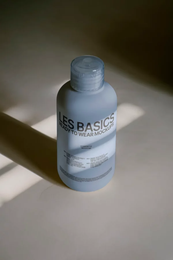 Frosted cylindrical soap bottle mockup with clear flip cap, captured in soft sunlight on a beige surface. Size: 100 x 175 mm.