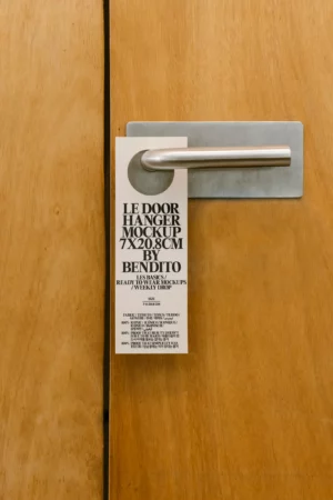 Door hanger mockup on wooden door handle in minimal setting.