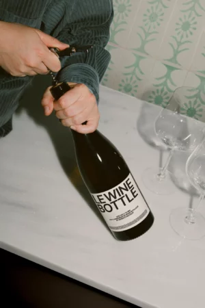 Wine bottle mockup on a wooden surface with a white background.