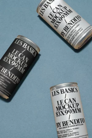 Three cylindrical cans with LES BASICS LE CAN MOCKUP 83x99MM BY BENDITO labels, two in white and one in black, arranged diagonally on a textured blue surface.