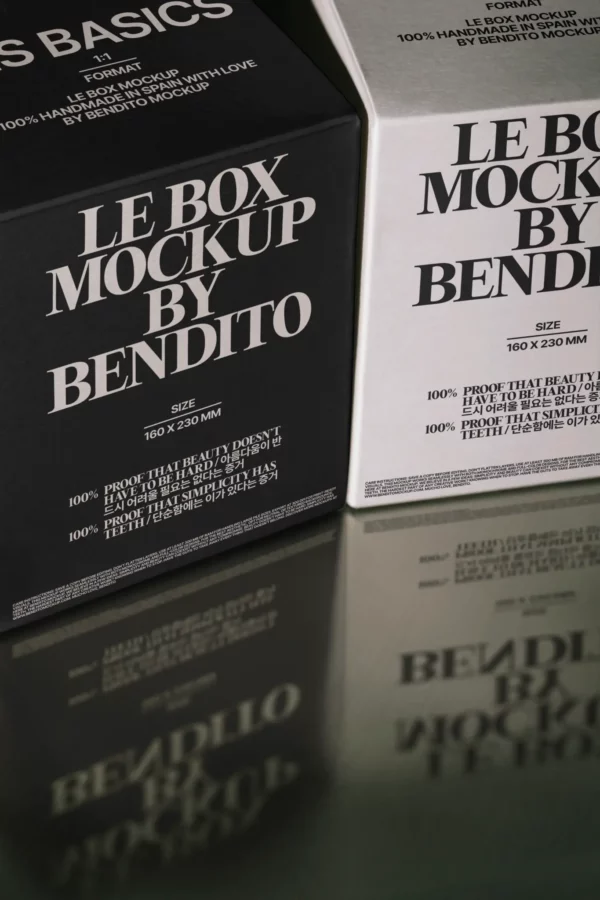 Two cardboard boxes, one black and one white, are positioned side by side. Both display the text LE BOX MOCKUP BY BENDITO along with size and product details, reflected slightly on the shiny surface below.