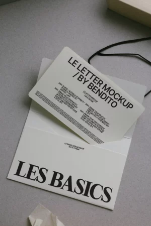 A mockup letter with bold black text partially pulled out of a white envelope labeled LES BASICS lies on a gray surface. The letter reads LE LETTER MOCKUP / BY BENDITO along with smaller sample text.