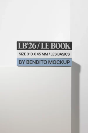 A stack of three rectangular boxes with text: LB26 / LE BOOK, SIZE 310 X 45 MM / LES BASICS, and BY BENDITO MOCKUP, set against a minimal white background on a ledge.
