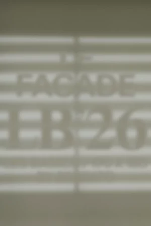 Blurred image of horizontal lines with the text “FACADE EB-26” and smaller, unclear text beneath, all appearing as if cast in shadow on a light surface.