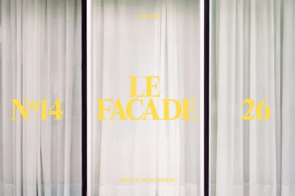 A large window covered with sheer white curtains. Yellow text on the glass reads LE FACADE in the center, Nº14 on the left, and 26 on the right. Smaller text above and below is faintly visible.